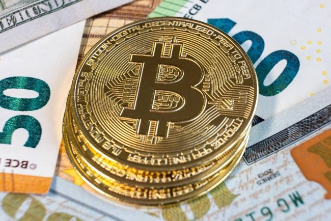 Close up of metal shiny bitcoin crypto currency coins on US doll Bitcoin auf Eurobanknoten