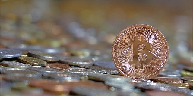 Bitcoin Münze neben Münzgeld Bitcoin Münze neben Münzgeld